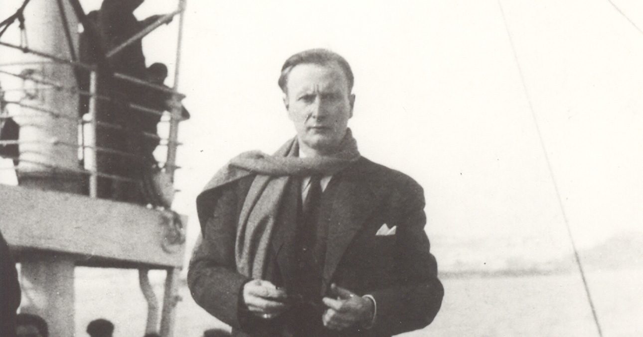 Photo of Armand Marquiset in a three-piece suit. He is on a boat.