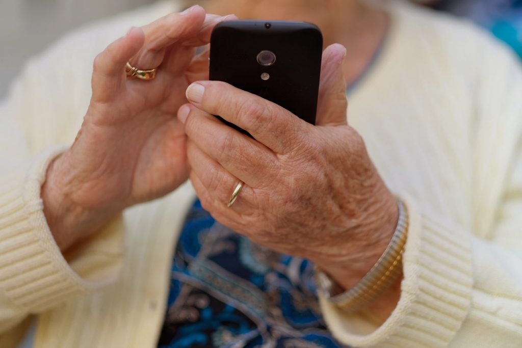 Photo d'une aînée qui utilise une téléphone cellulaire.