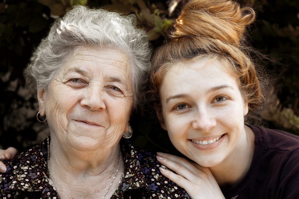 Close-up of an elderly woman and a young woman posing for the camera.