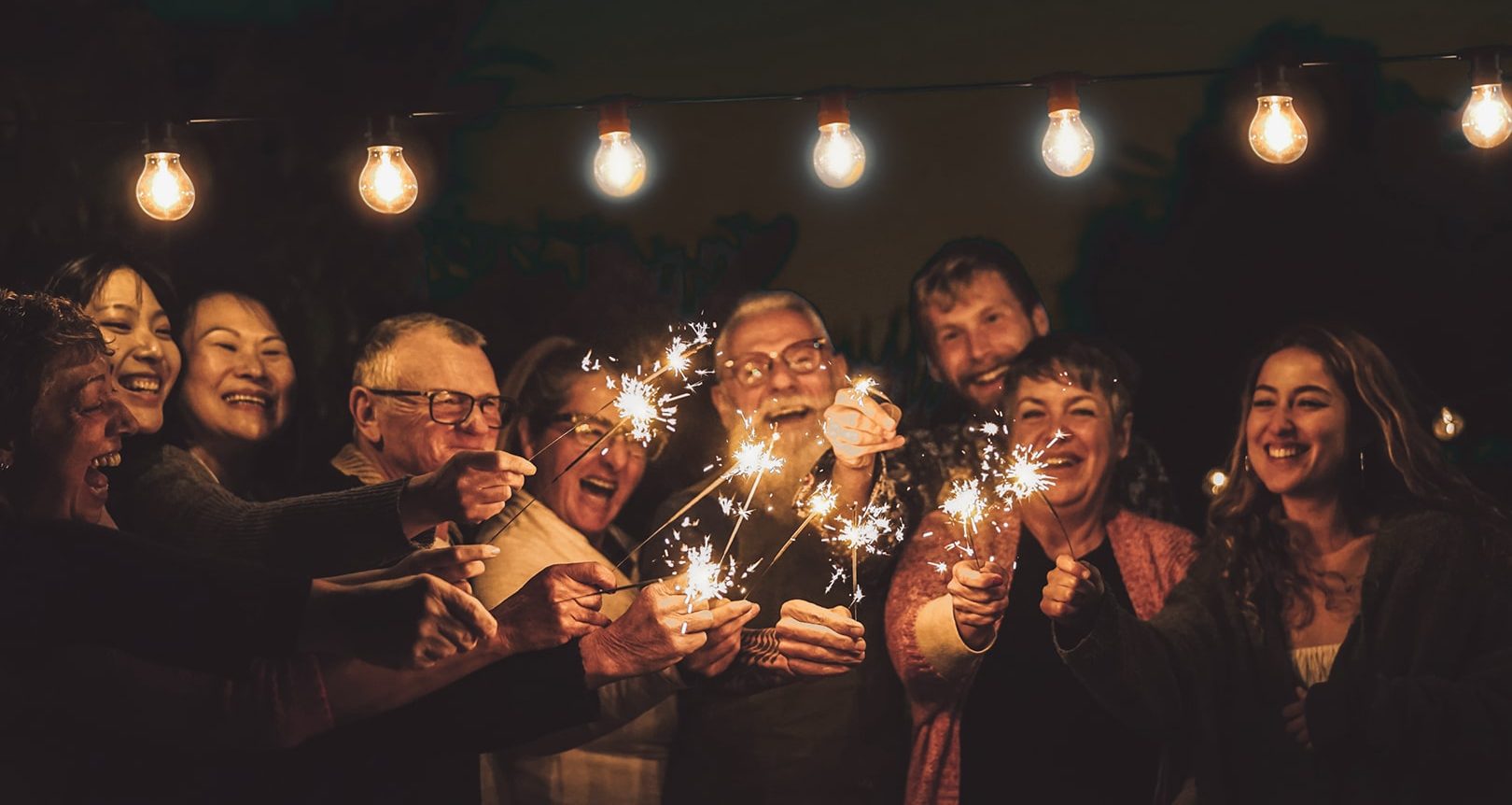 Photo of several people holding sparklers.