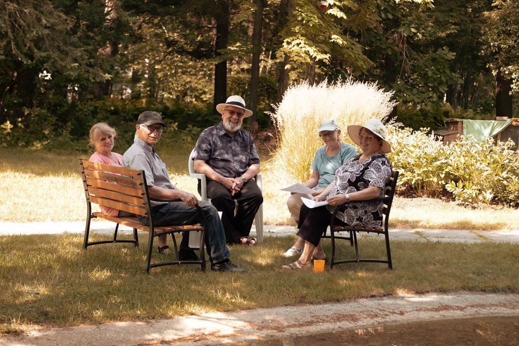 Photo d'un groupe d'aînés sur des bancs à l'extérieur.