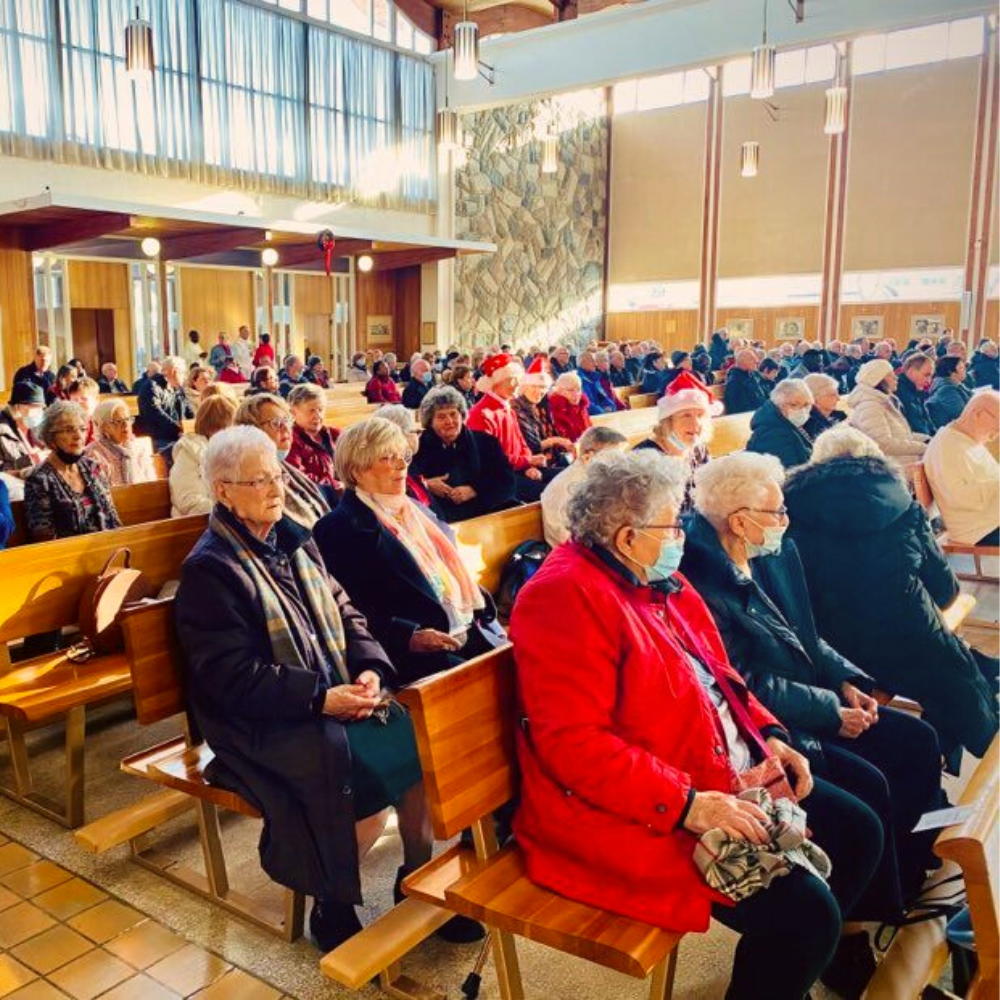 Photo de plusieurs aînés dans une église moderne.