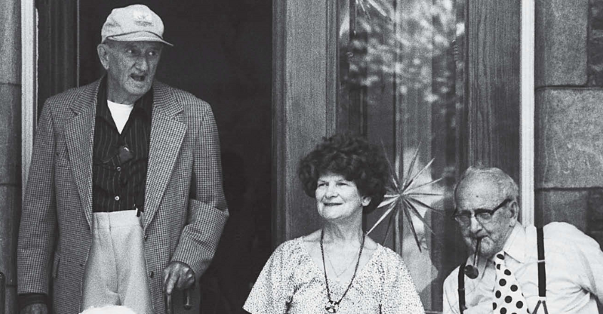 Vieille photo qui représente trois personnes âgées devant une maison -couverture du rapport annuel 2021-22