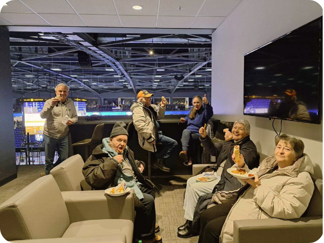 Des personnes qui mangent dans une loge d'une partie de hockey