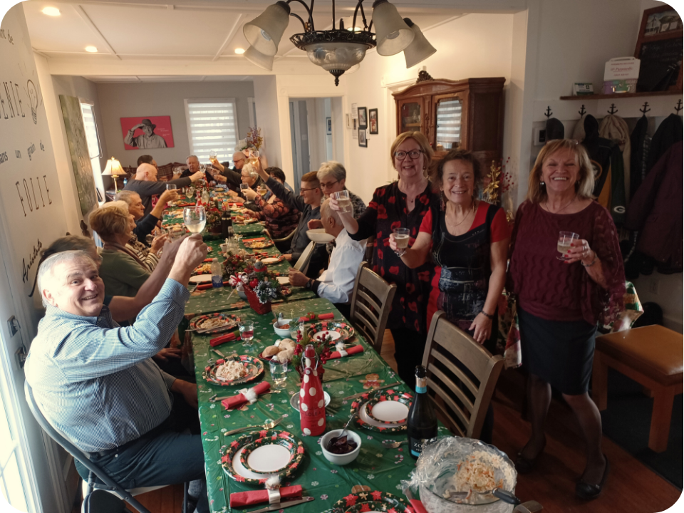 Un groupe de personne, verre à la main, qui regarde la caméra en souriant.
